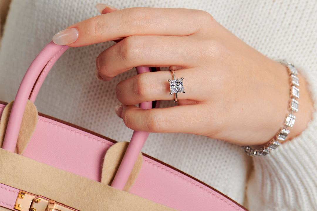 Lady wearing a princess cut engagement ring ring set in 4 claws