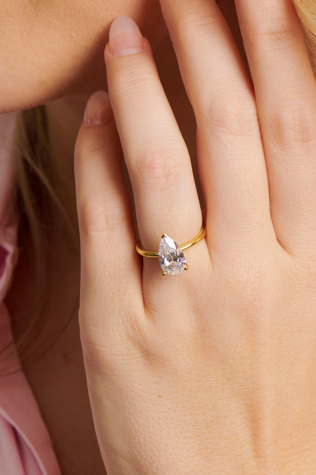 Lady wearing the Josephine pear shaped diamond engagement ring set in 3 claws with a plain band