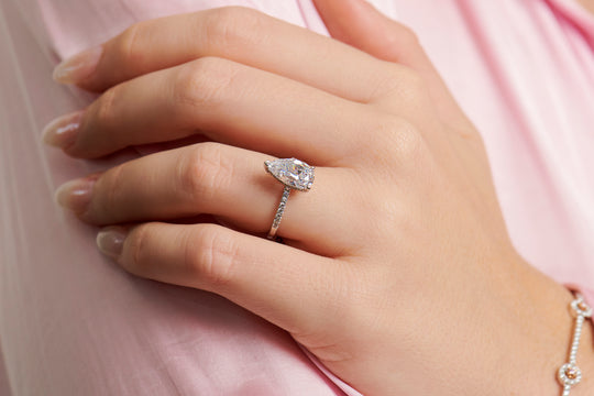 Lady wearing the Maria Pear cut engagement ring adorned by round brilliant cut diamond band