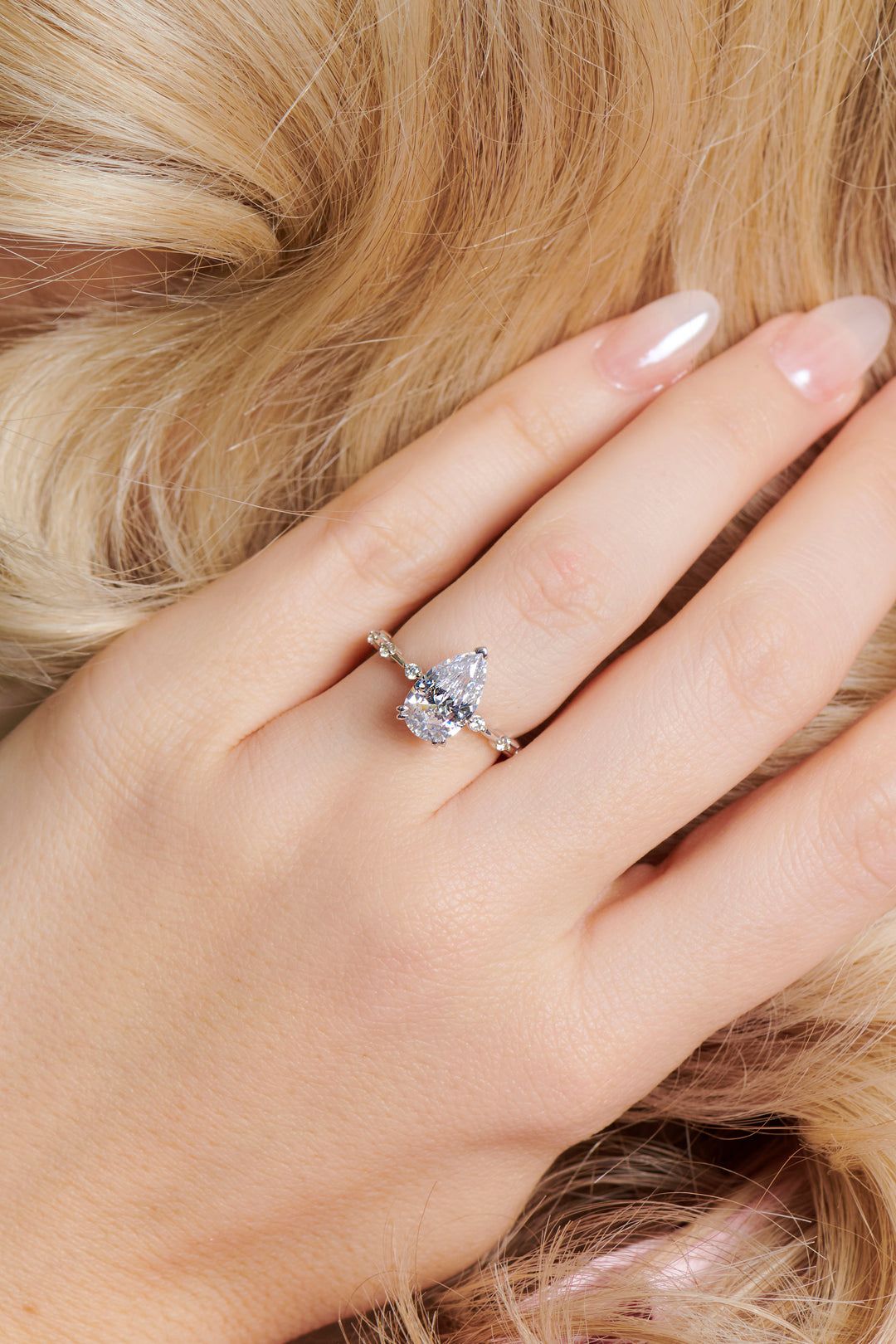 Pear shaped diamond engagement ring set in 3 claws set on a round brilliant cut diamond band