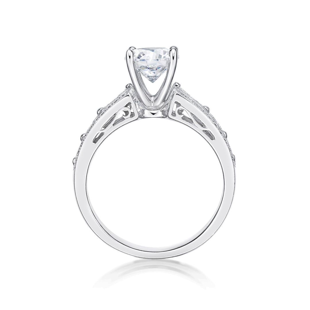 The Bijou features a round brilliant cut diamond centre adorned by princess cut diamonds single claw set into the shoulders of the band