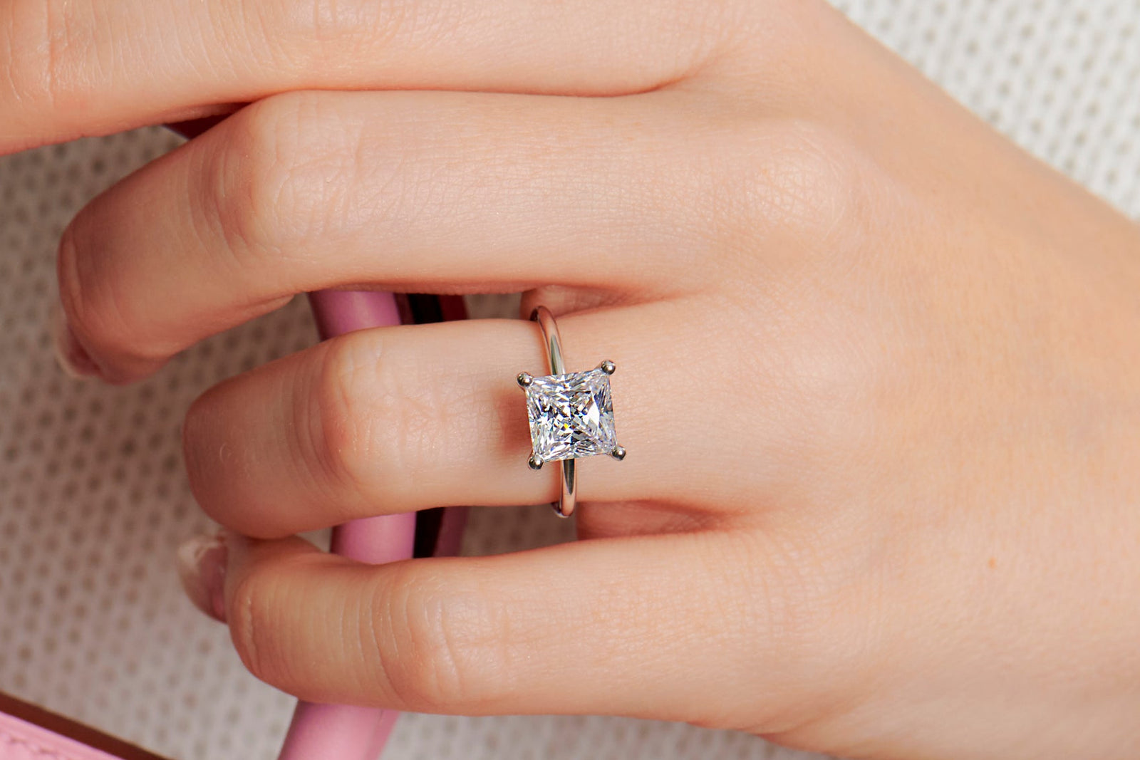 Lady wearing a princess cut engagement ring ring set in 4 claws