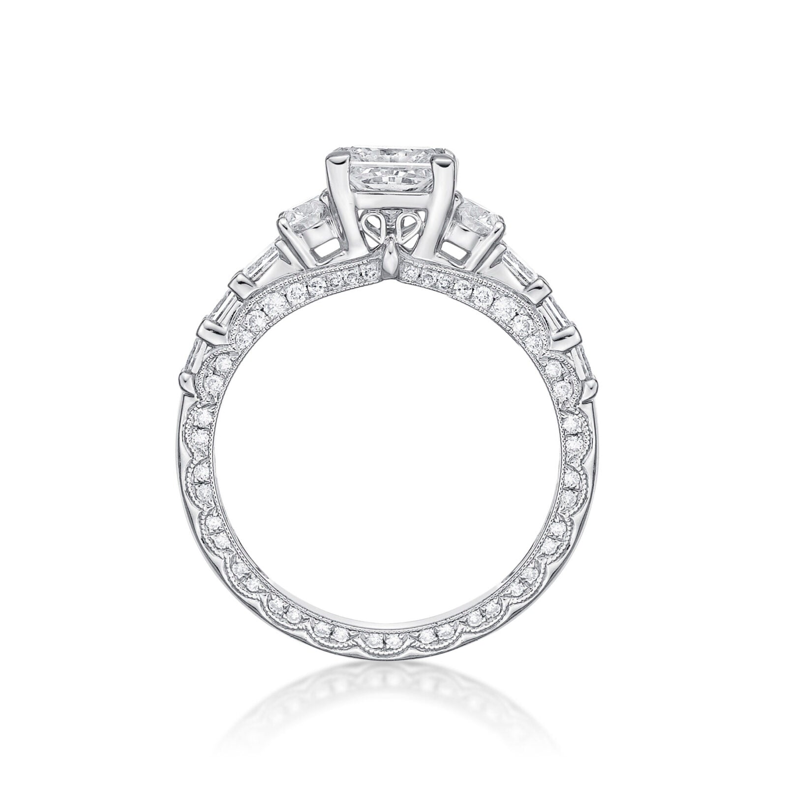 The Amelia princess cut engagement ring features Round brilliant cut diamonds grain set into each side, finished with millgrain detailing in a scalloped design