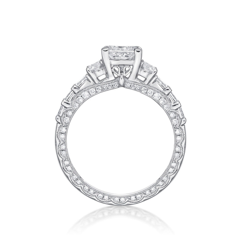 The Amelia princess cut engagement ring features Round brilliant cut diamonds grain set into each side, finished with millgrain detailing in a scalloped design