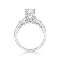 The Bijou features a round brilliant cut diamond centre adorned by princess cut diamonds single claw set into the shoulders of the band 