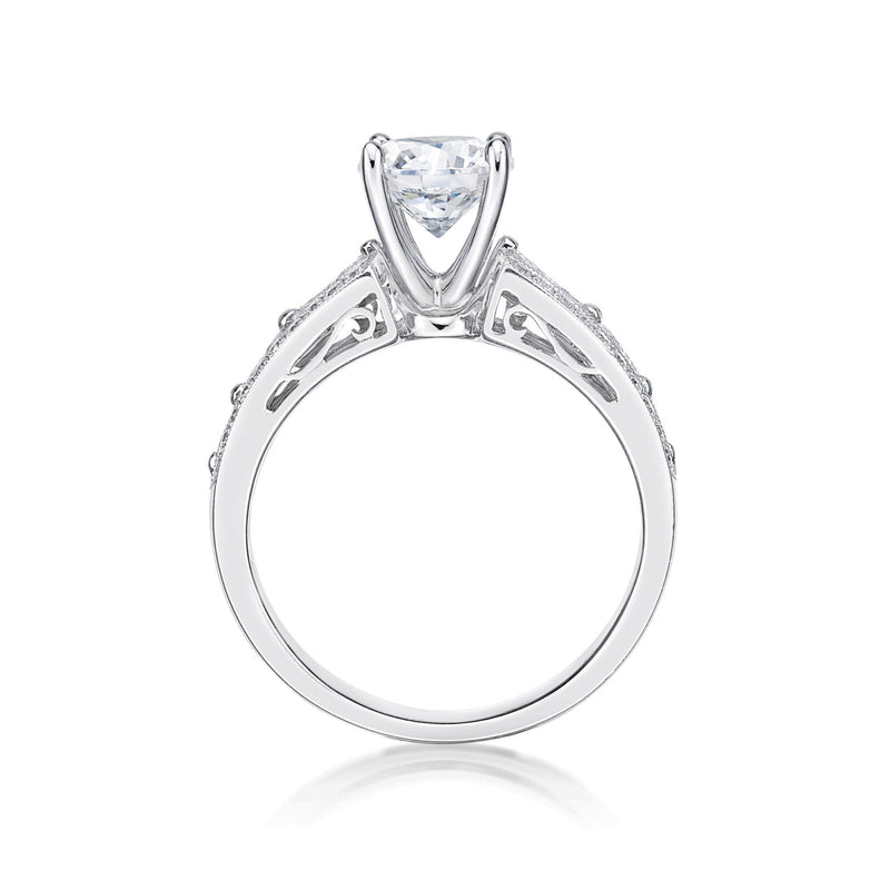 The Bijou features a round brilliant cut diamond centre adorned by princess cut diamonds single claw set into the shoulders of the band 